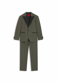 Olivgrüner Anzug mit schwarzen Revers, taillierte Passform, zwei Fronttaschen und drei Knopfdetails an den Ärmeln. Rotes Markenlabel innen.