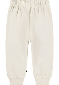 Ljusbeige bomullbyxor med elastisk midja, avsmalnande ben och ribbade cuffs vid anklarna. Enkel, slät textur utan mönster.