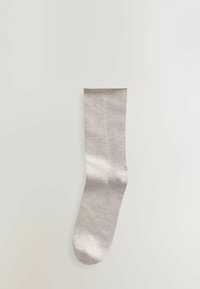 Lys grå socke lavet af glat stof med en ensfarvet overflade, der har en ribbet kant og en rund tå. Ingen synlige mønstre eller detaljer.