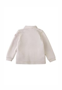 Giacca color crema con texture, maniche lunghe e una piccola toppa circolare sulla parte superiore del braccio sinistro, vista da dietro.