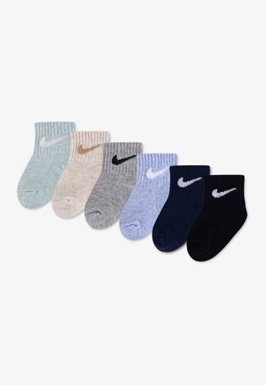 Sześć par prążkowanych skarpet do kostki w pastelowej zieleni, beżu, szarości, niebieskiego, granatu i czerni, każda para z logo Nike swoosh z boku.