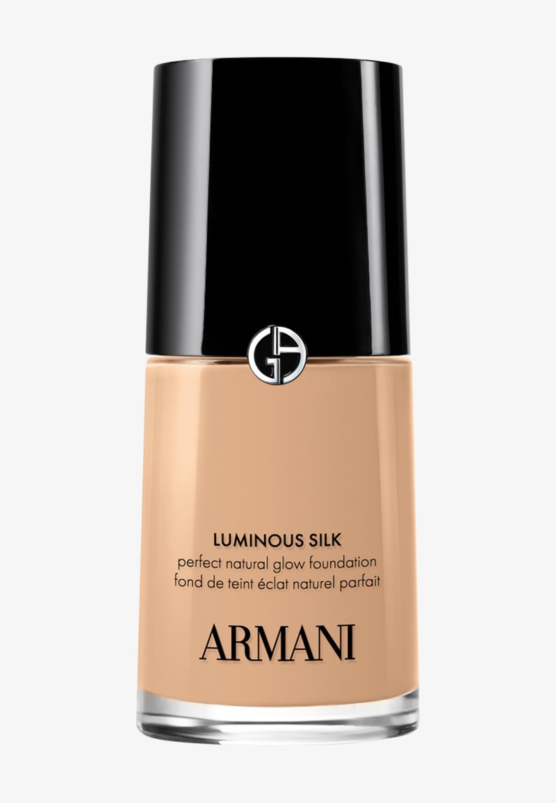 Flesje Armani Luminous Silk foundation met zwarte dop, beige vloeibare foundation en logo op een witte achtergrond.