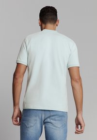 Lichtblauw katoenen t-shirt met korte mouwen, een ronde hals en een aansluitend ontwerp. Heeft een gladde textuur en een eenvoudige achterkant.