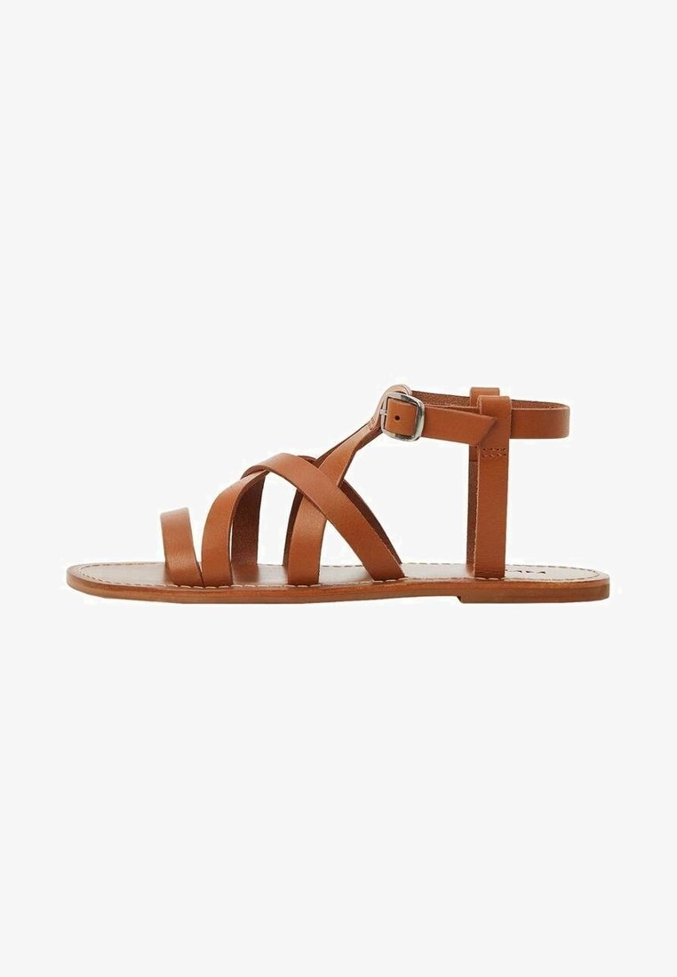Sandale plate en cuir marron avec plusieurs brides et une fermeture à boucle à la cheville sur fond blanc.