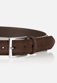 Brun ruskindsbælte med en sølvfarvet metalbuckle, justerbar med flere huller, og en glat tekstur med et klassisk design.