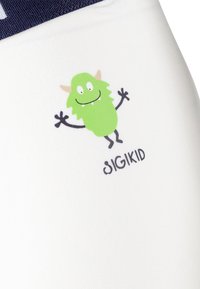 White fabric with a green monster graphic, featuring a smiling face, arms outstretched, and the text "sigikid" below.
