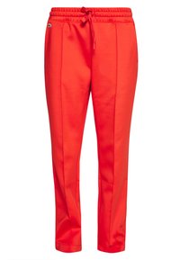 Rode joggingsbroek met een elastische tailleband, sluiting met trekkoord en zijnaden. Bevat een klein logo op de linker heup. Glad materiaal.