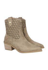 Botines de ante beige con un patrón recortado en el eje, punta afilada y tacón de madera apilada. Presentan botones de acento en tono dorado.