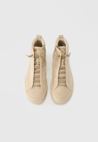 Μπεζ πάνινα ψηλά παπούτσια με σουέντ υφή, σύστημα φερμουάρ και κορδονιών, στρογγυλή μύτη και διακοσμητικά σχέδια στην πλευρά με υφή. Μαλακή εσωτερική επένδυση.