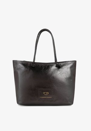 Bolso tote de cuero negro con asas dobles, acabado liso y un pequeño parche con la inscripción "V°73 Gold Elisabetta Armellin" en letras doradas.
