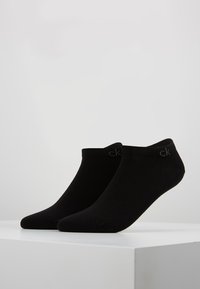 Calcetines negros de tobillo hechos de una mezcla de algodón, con una parte superior acanalada y un pequeño logo. Textura suave con un diseño sin costuras para mayor confort.