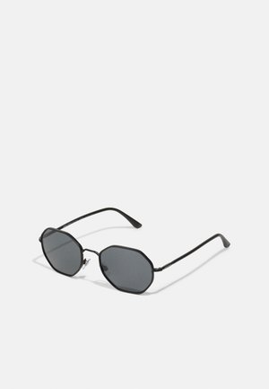 Schwarze achteckige Sonnenbrille mit getönten Gläsern, dünnem Metallrahmen und geraden Bügeln. Minimalistisches Design ohne dekorative Akzente.