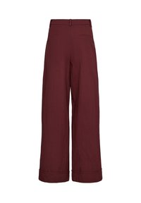 Pantalon bordeaux à jambes larges, taille haute, avec passants de ceinture, ourlets retroussés et poches passepoilées au dos, présenté sur fond blanc.