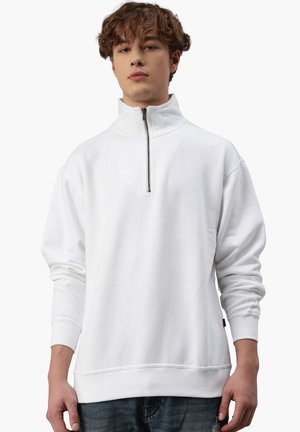 Felpa bianca con zip, colletto alto, vestibilità rilassata, polsini e fondo a costine, texture morbida e una piccola etichetta logata di lato.