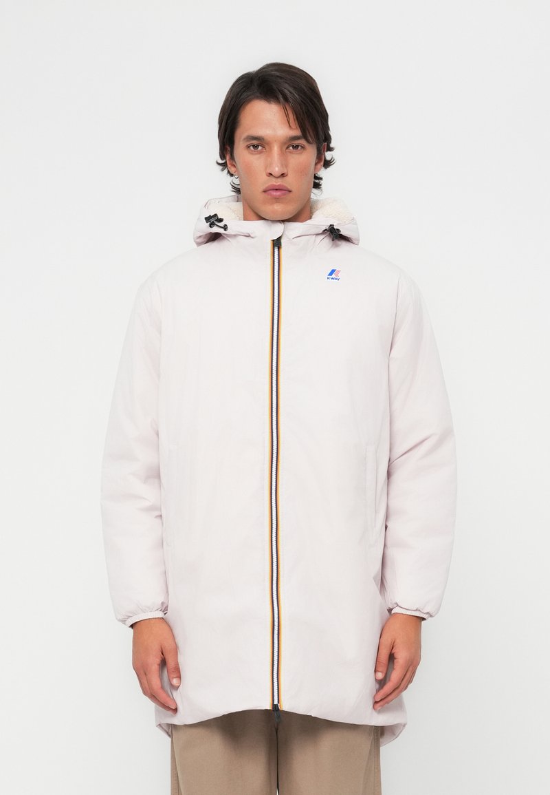 Parka rose clair avec capuche ajustable, fermeture éclair avant avec une bande de couleur, poignets élastiques et un petit logo sur la poitrine.