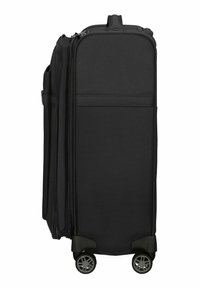 Valise à roulettes noire fabriquée en tissu durable, avec un design structuré, des roues à roulement fluide et une fermeture zip.