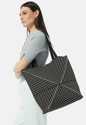 Schwarz-weiße gestreifte Tragetasche mit einem geometrischen Zickzackmuster, ausgestattet mit stabilen schwarzen Griffen und einer weichen Stofftextur.