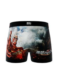 Caleçons avec un graphique du Titan Colossal tendant la main sur un fond enfumé et enflammé, avec le texte "Attack on Titan" en japonais et en anglais.