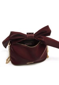 Borsa a tracolla in pelle bordeaux con chiusura a forma di fiocco, tracolla in catena dorata, tasca con zip e finitura liscia.