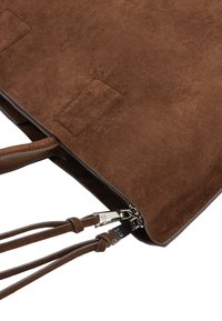 Brązowa torebka zamszowa o fakturowanej powierzchni, zamykana na zamek błyskawiczny, z paskami ze skóry. Posiada srebrne okucia i minimalistyczny design.