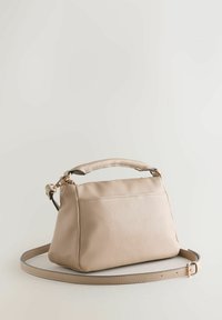 Bolso de mano de cuero beige con forma estructurada, asa superior y correa ajustable. Cuenta con cierre de cremallera y detalles sutiles de costura.