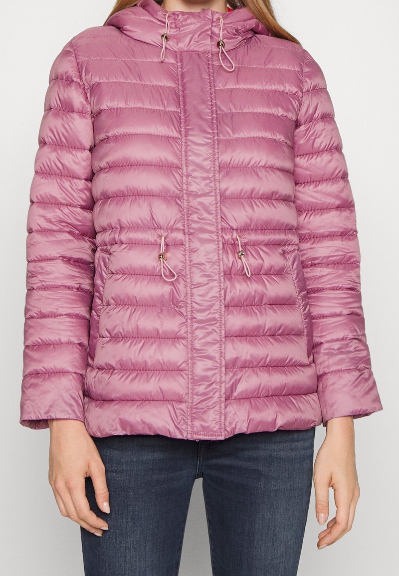 Uppblåst jacka i ljusrosa, med dragkedja fram, två sidofickor, justerbar huva med dragsnören och horisontellt quiltat mönster.