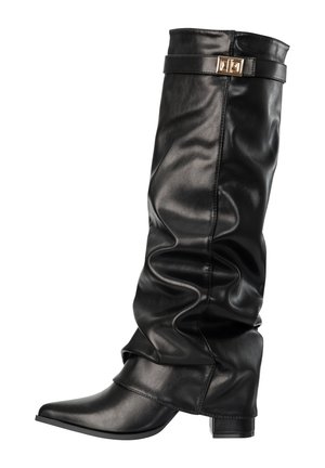 Bota negra de cuero holgada hasta media pantorrilla, con punta puntiaguda, tacón ancho y una correa decorativa con hebilla dorada cerca de la parte superior.