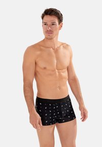 Boxer-briefs en coton noir ornés d'un motif de petits crânes et de roses, avec une taille élastique noire affichant le logo "HOM".