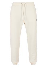 Pantalones de chándal color crema con cinturilla elástica, cordón ajustable y puños acanalados. Presenta un pequeño logo en el lateral.
