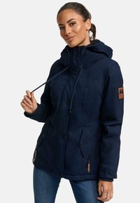 Navy blue hooded jacket featuring a zippered side pocket, button closures, and a textured fabric, with a leather logo patch on the sleeve.