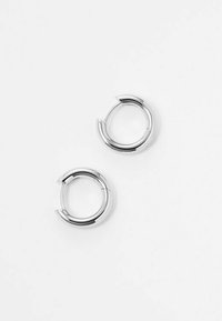 Orecchini a cerchio in argento con una finitura liscia e lucida. Presentano un design elegante e una leggera apertura nella forma circolare.