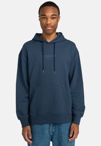 Navy blue hooded sweatshirt in cotton blend, featuring a kangaroo pocket, ribbed cuffs, and subtle logo on the chest. Relaxed fit design.