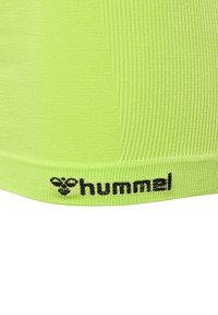 Neon zielony sportowy top crop z prążkowanej tekstury, z czarnym logo "hummel" na dolnym brzegu.