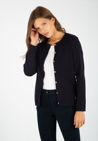 Granatowy kardigan uszyty z miękkiego materiału, z okrągłym dekoltem, długimi rękawami i złotymi guzikami na przodzie.