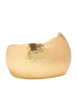 Szeroka, młotkowana, złotego koloru zakrzywiona bransoletka mankietowa o gładkim, błyszczącym wykończeniu na białym tle.