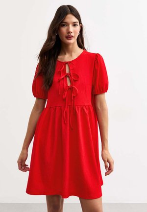 Vestido rojo con mangas abullonadas, tejido texturizado, detalle de lazo en el frente y falda acampanada, que ofrece un ajuste relajado y un color vibrante.