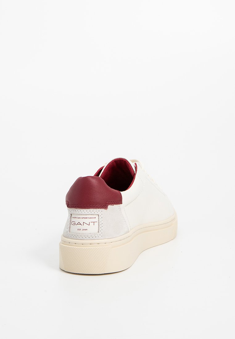Vita sneakers med röda läderdetaljer, texturerad gråmocka och en tjock gummisula. Har varumärkeslogotyp på hälfliken.