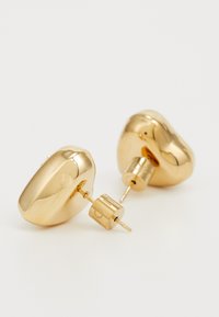 Gold-toned stud earrings with a smooth, rounded shape and a shiny finish; featuring a post and backing for secure wear.
