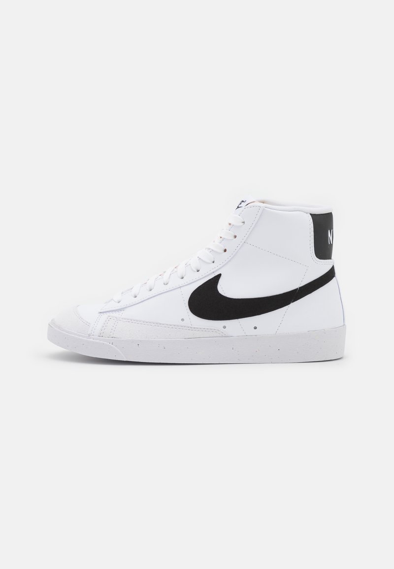 Sapatilhas altas em couro branco com um swoosh da Nike em camurça preta e um painel traseiro preto. Inclui atacadores brancos e uma sola de borracha texturizada.