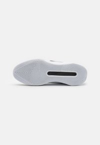 Nike sneakersål, hvid gummi med struktureret zigzag-mønster, med et sort ventilationsområde og glatte buede linjer på overfladen.