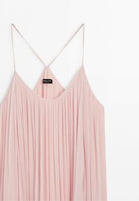Light pink sleeveless dress with thin adjustable straps and a pleated flowing fabric, shown on a white background.