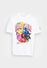 Witte katoen t-shirt met een kleurrafieke afbeelding van superhelden in verschillende poses, met vetgedrukte tekst "KIES JE HELD" in rood en geel.