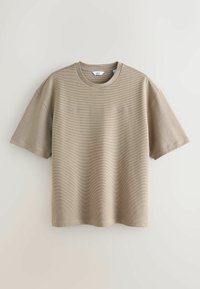 Beige t-paita lyhyillä hihoilla, valmistettu teksturoidusta puuvillasta, jossa on hienovaraisia vaakasuoria raitoja ja brodeeratut kirjainpainatukset rinnassa.
