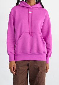Pink hoodie with a front pocket, drawstring hood, and white Nike logo on the chest. Features ribbed cuffs and hem. Cotton blend fabric.