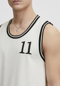 Hvit mesh basketball jersey med svart ribbet kant og tallet "11" i fet svart. Nærbilde med fokus på design og tekstur.