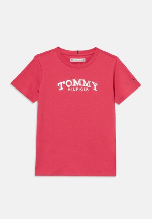 Růžové bavlněné tričko s krátkými rukávy, kulatým výstřihem a bílým logem "TOMMY HILFIGER" potištěným na přední straně. Jednoduchý design bez vzorů.