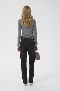 Mørk denimjeans med høyt liv, et brunt belte og en grå langermet topp. Figuren holder en liten brun veske og har på seg sko med skrå hæler.