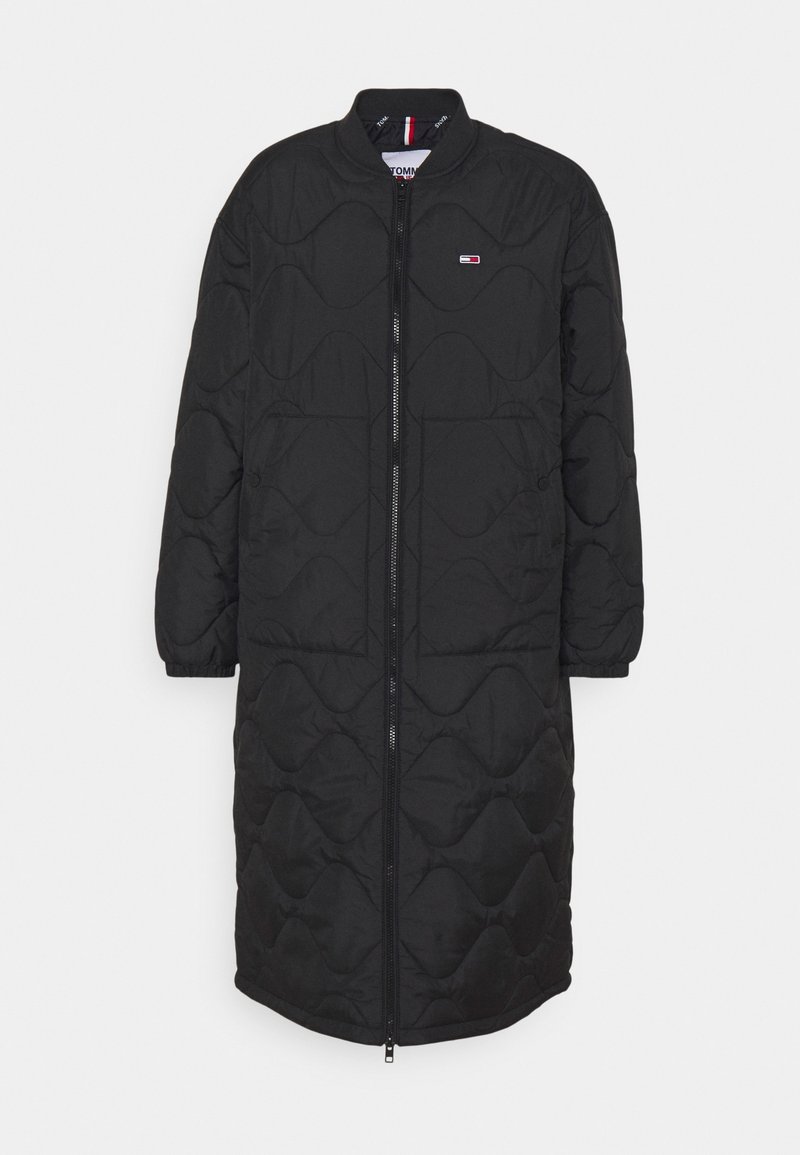 Abrigo largo negro acolchado con un diseño estructurado, que presenta un cierre con cremallera, un cuello redondeado y sutiles acentos metálicos.