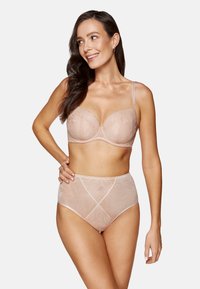 Biustonosz i wysoka bielizna w kolorze nude, z koronkowym nadrukiem w kwiaty, wsparciem w postaci fiszbin oraz przezroczystym materiałem z poziomymi i pionowymi liniami.