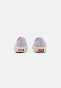 Lilasfarbene Leinenschlupfschuhe mit runder Zehenpartie und weißen Gummisohlen. Mit einem roten und weißen Gummilogo-Patch an der Ferse.